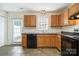 Bright kitchen featuring tile floors, wood cabinets, black appliances, and lots of light at 128 Locomotive Ln # 110, Mooresville, NC 28115