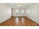 An empty living room showing wood floors, neutral walls, and bright natural light at 128 Locomotive Ln # 110, Mooresville, NC 28115