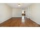 Empty living room showcasing hardwood floors, neutral paint, and a ceiling fan at 128 Locomotive Ln # 110, Mooresville, NC 28115