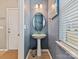 Stylish powder room with a pedestal sink, oval mirror, and blue walls for a modern, fresh feel at 15954 Harbor Hill Dr, Charlotte, NC 28273