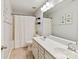 Bright bathroom featuring a double vanity, neutral tile, and a shower/tub combo with a white curtain at 15954 Harbor Hill Dr, Charlotte, NC 28273