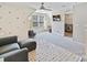 A vibrant bonus room features colorful polka dot wallpaper, TV, ceiling fan, and entry to laundry room at 15954 Harbor Hill Dr, Charlotte, NC 28273