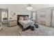 Elegant main bedroom with chandelier, mirrored furniture, decorative pillows, and plush gray rug at 15954 Harbor Hill Dr, Charlotte, NC 28273