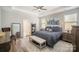 This main bedroom features a tray ceiling, ceiling fan, and a seating bench at the foot of the bed at 1715 Rhynes Trl, Rock Hill, SC 29732