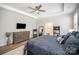 This main bedroom boasts a tray ceiling, ceiling fan, and a dresser with a television at 1715 Rhynes Trl, Rock Hill, SC 29732