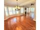 Spacious living room featuring hardwood floors, large windows with shutters, and a fireplace at 18845 Cloverstone Cir, Cornelius, NC 28031