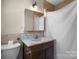 Bathroom with tile surround, vintage vanity and mirror, and shower with curtain at 2530 31St Street Ne Dr, Hickory, NC 28601