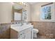 Bathroom featuring a vanity, mirror, and tiled backsplash, complemented by a window providing natural light at 2530 31St Street Ne Dr, Hickory, NC 28601