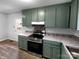 Updated kitchen features painted cabinets, stone counters, and vinyl flooring at 2725 Fair Oaks Dr, Gastonia, NC 28054