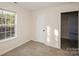 This bedroom features a large window, neutral carpet and an entry door, providing functionality and style at 2868 Oasis Ln, Charlotte, NC 28214