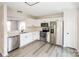 Bright kitchen featuring white cabinets, stainless steel appliances, and light wood floors at 2868 Oasis Ln, Charlotte, NC 28214