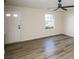 Bright living room featuring wood-look flooring, ceiling fan, and a window allowing natural light at 2868 Oasis Ln, Charlotte, NC 28214