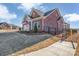 Angle view of a brick house showing the side yard, metal fence and well-maintained landscaping at 3069 Founding Fathers Dr, Gastonia, NC 28056