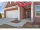 Brick home featuring a two-car garage, an American flag and covered porch at 3069 Founding Fathers Dr # 38, Gastonia, NC 28056