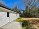 A cozy backyard with a concrete patio, grass, and ample privacy from mature trees at 324 Ashford St, Chester, SC 29706