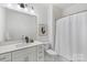 Well-lit bathroom with a shower, toilet, single sink vanity and modern lighting at 3413 Holabird Ln # 10, Charlotte, NC 28208