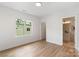 Bright bedroom with light wood floors, a large window, and en suite bathroom at 3413 Holabird Ln # 10, Charlotte, NC 28208