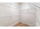 Walk-in closet with white wire shelving and wood-look flooring at 3413 Holabird Ln # 10, Charlotte, NC 28208