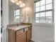 Bathroom with granite countertop, wood cabinets, and square window for natural light at 423 Castlebury Ct, Clover, SC 29710