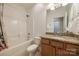 Well-kept bathroom with tub, granite vanity, neutral tile, and convenient storage at 423 Castlebury Ct, Clover, SC 29710