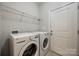 Functional laundry room with washer, dryer, shelving, and easy outdoor access at 423 Castlebury Ct, Clover, SC 29710