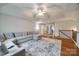 Hardwood living room with neutral walls, sectional seating, ceiling fan, and staircase at 423 Castlebury Ct, Clover, SC 29710