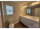 Bright bathroom featuring double vanity, large mirror, tiled floors, and a toilet at 4254 Black Ct # 170, Harrisburg, NC 28075