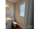 Clean, well-lit powder room with white fixtures, vanity, and a window at 4254 Black Ct # 170, Harrisburg, NC 28075