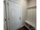 Functional entryway with a coat rack, bench, and storage, adjacent to a white paneled door at 4254 Black Ct # 170, Harrisburg, NC 28075