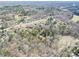 The aerial view shows a lush, expansive landscape with homes nestled among dense woodlands and a tranquil pond at 4450 Flowes Store Rd, Concord, NC 28025