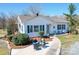 Charming single story home with a welcoming porch, manicured landscaping, and outdoor seating at 4450 Flowes Store Rd, Concord, NC 28025
