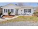 Cozy single-story home with a well-maintained lawn and inviting front porch with rocking chairs at 4450 Flowes Store Rd, Concord, NC 28025