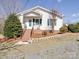 Charming one-story house with brick stairs and well-maintained garden beds and greenery at 4450 Flowes Store Rd, Concord, NC 28025