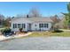 Beautiful one-story house with well-manicured front yard, walkway and outdoor seating at 4450 Flowes Store Rd, Concord, NC 28025