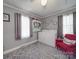 Functional laundry room with washer, dryer, open shelving, and a cozy red armchair at 4450 Flowes Store Rd, Concord, NC 28025