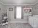 Well-lit laundry room with open storage shelving and modern gray accents at 4450 Flowes Store Rd, Concord, NC 28025