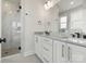 Modern bathroom with double vanity, stone countertops, and a walk-in shower with glass enclosure at 5003 Tiny Ln, Charlotte, NC 28203