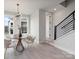 Bright dining area features modern light fixture, wood table, and access to stairs at 5003 Tiny Ln, Charlotte, NC 28203