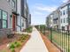 Landscaped walkway between modern townhomes, featuring fresh plants and mulch at 5003 Tiny Ln, Charlotte, NC 28203