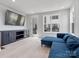 Modern living room boasts large TV, built-in cabinets, and blue sectional seating at 5003 Tiny Ln, Charlotte, NC 28203