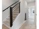 Modern staircase with black metal railings and light wood steps at 5003 Tiny Ln, Charlotte, NC 28203