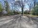 Spacious paved driveway bordered by mature trees, offering ample parking and a natural setting at 507 6Th W Ave, Gastonia, NC 28052