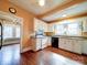 Corner view of white kitchen showcasing countertops, appliances, updated flooring, and natural light at 507 6Th W Ave, Gastonia, NC 28052