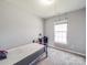 This bedroom features neutral paint, carpeted floors, a desk, and one window at 5414 Peachwood Dr, Charlotte, NC 28216