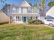 Charming two-story home boasts a welcoming front porch and well-manicured lawn at 5414 Peachwood Dr, Charlotte, NC 28216