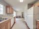 Bright kitchen with white refrigerator, wood cabinets and view into dining area at 5414 Peachwood Dr, Charlotte, NC 28216