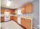 Well-lit kitchen with wood cabinets, white appliances, and a window over the sink at 5414 Peachwood Dr, Charlotte, NC 28216