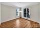 A dining room features hardwood flooring, two windows, crown molding, and modern lighting at 6141 Creft Cir, Indian Trail, NC 28079