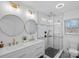 Modern bathroom with double vanity sinks, round mirrors, and a glass-enclosed shower at 6301 Vernedale Rd, Charlotte, NC 28212