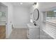 Bright bathroom featuring a modern vanity, round mirror, and tiled floors at 6301 Vernedale Rd, Charlotte, NC 28212